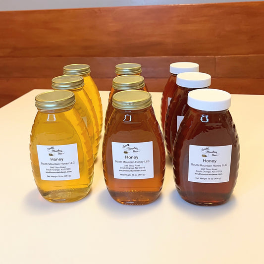 9 honey jars of 3 different colors: light, amber, and dark. Each submission to the 2022 Honey Show consists of 3 jars of one pound of honey each.