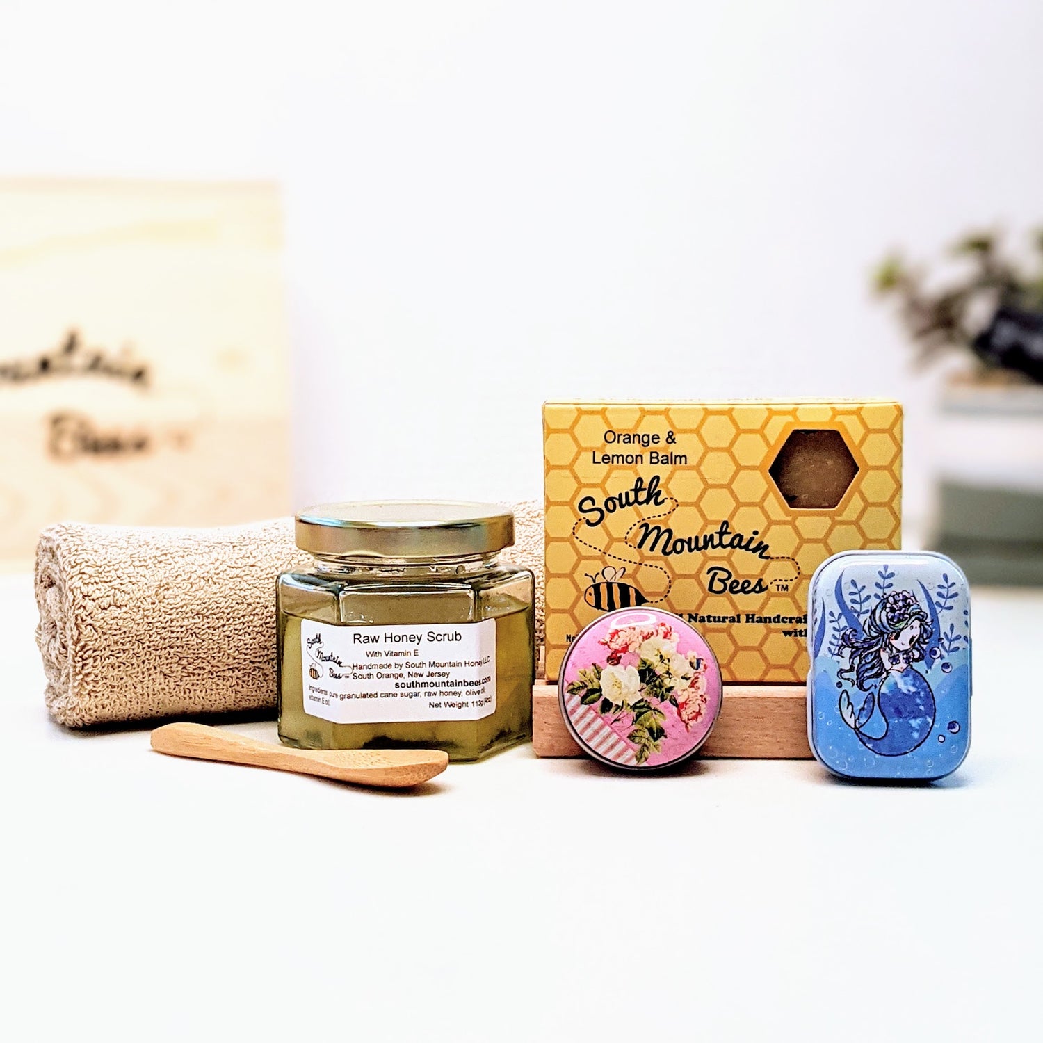 A bundle of bath and body products including soap, lip balm, salve, scrub, soap dish and washcloth.