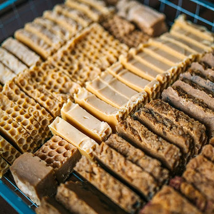 An assortment of honey soaps in a curing tray.