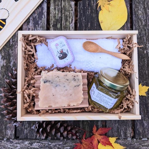 The Pampering Gift Box has a raw honey scrub with bonus bamboo spoon, a natural honey soap, a soothing salve with dandelion infused oils, a beech wood soap dish, and a hotel grade 100% cotton washcloth. It all comes in the most charming, reusable sliding top wooden box.